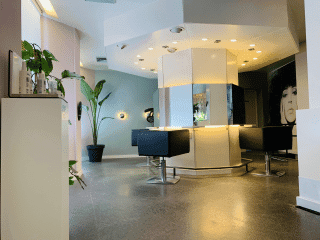 Kappersstoelen en spiegels in de salon, met planten bij het raam